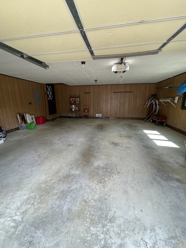 garage with a garage door opener and wooden walls