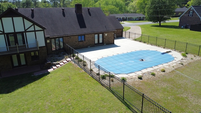 view of swimming pool with a lawn and a patio area