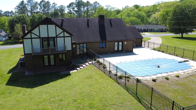 back of house with a lawn and a patio area