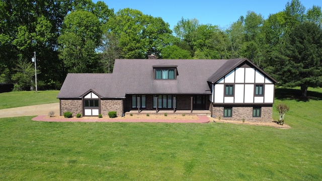 tudor-style house featuring a front yard