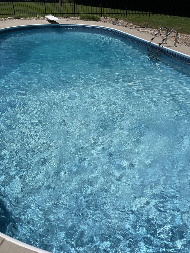 view of swimming pool with a diving board