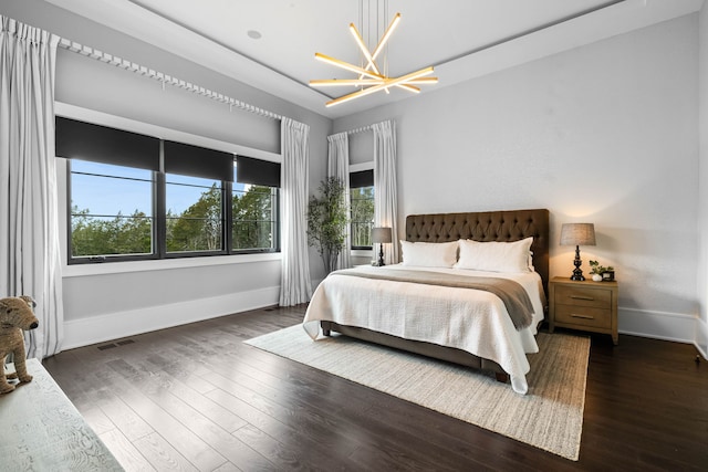 bedroom featuring dark hardwood / wood-style flooring and an inviting chandelier