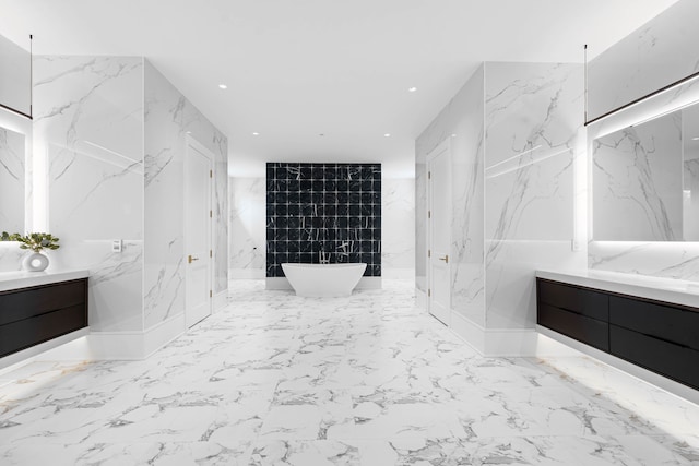 bathroom with tile flooring, walk in shower, vanity, and tile walls