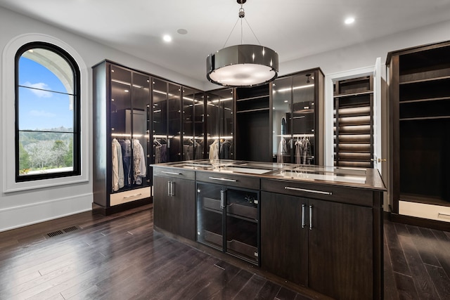 kitchen featuring stainless steel counters, dark hardwood / wood-style flooring, and decorative light fixtures