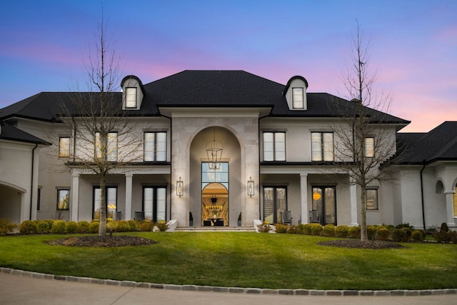 french country home featuring a lawn