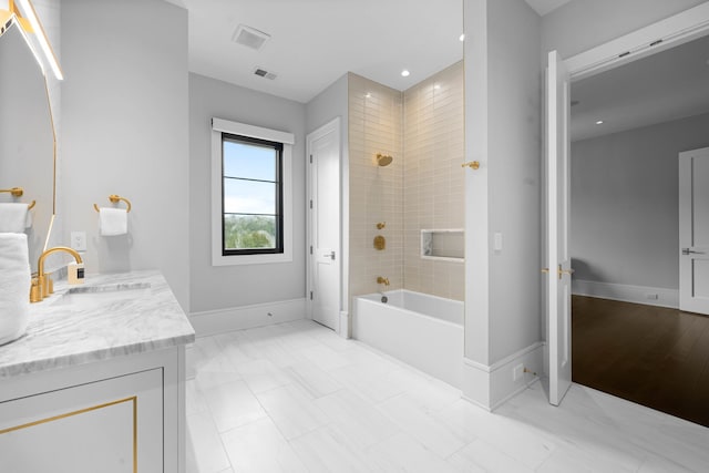 bathroom featuring tile floors, tiled shower / bath, and large vanity