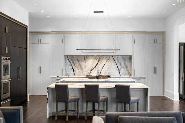 kitchen featuring a kitchen island, dark hardwood / wood-style floors, tasteful backsplash, and paneled built in refrigerator