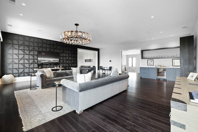 living room with dark hardwood / wood-style floors, a notable chandelier, and beverage cooler