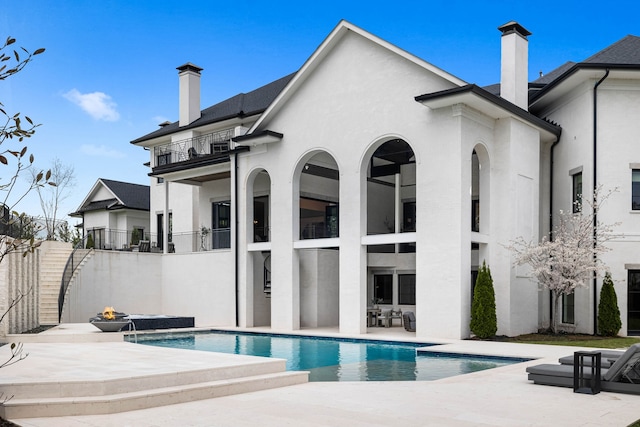 rear view of house with a balcony and a patio