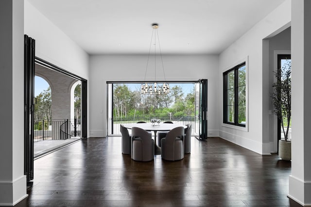 dining area featuring dark wood-type flooring and a notable chandelier