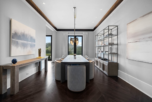 dining room with a chandelier, a raised ceiling, and dark parquet floors