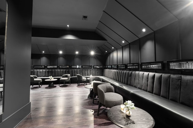 home theater room with hardwood / wood-style flooring and vaulted ceiling