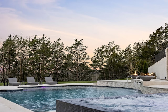 pool at dusk with pool water feature