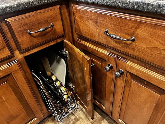 room details with brown cabinetry and dark countertops