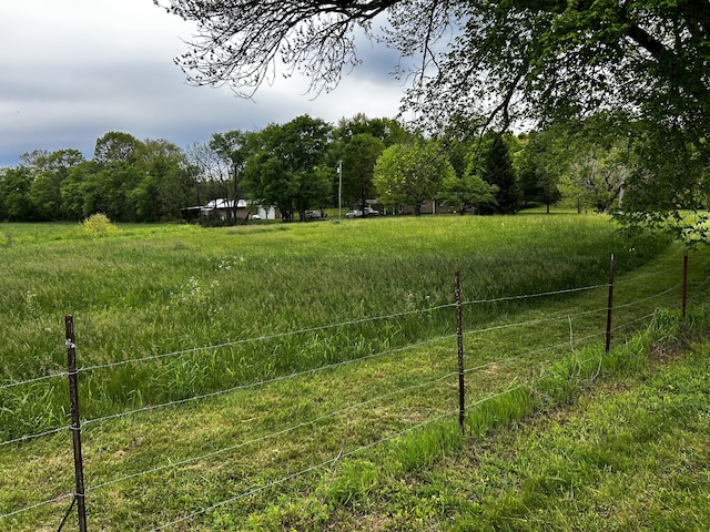 view of yard featuring a rural view and fence