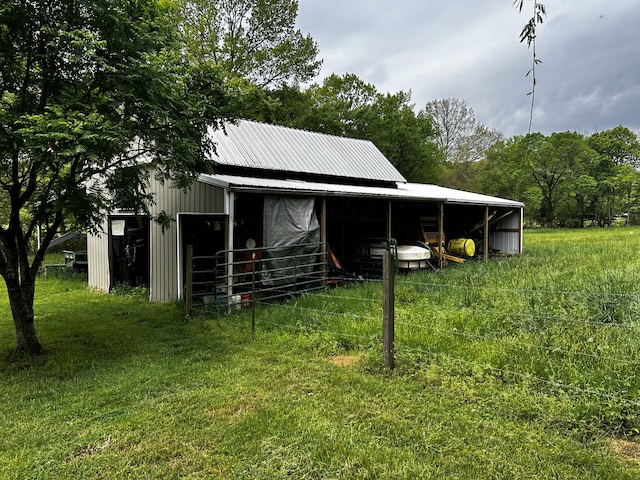 exterior space featuring a garage, a pole building, metal roof, and an outdoor structure