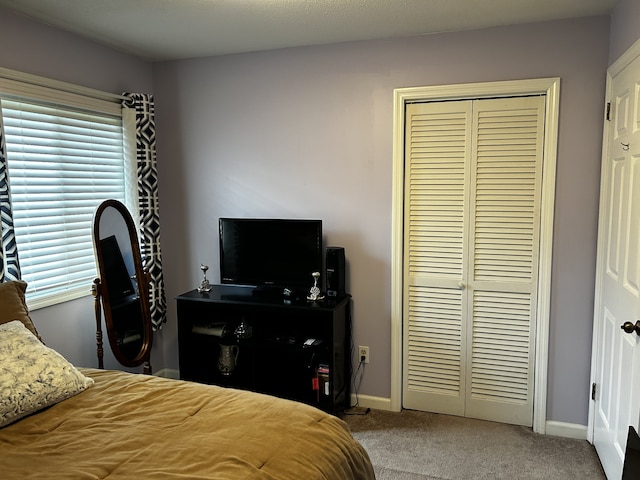 bedroom featuring light carpet, a closet, and baseboards