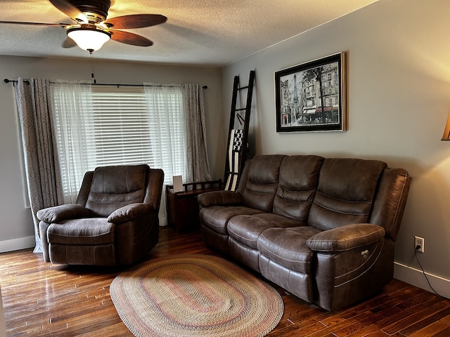 living room featuring baseboards, wood-type flooring, and a textured ceiling