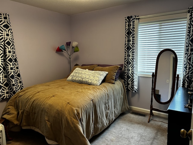 bedroom with carpet, visible vents, and baseboards