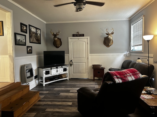 living room featuring heating unit, dark wood-style floors, wainscoting, and a textured ceiling