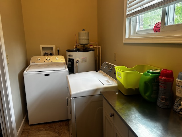 clothes washing area featuring baseboards, cabinet space, tile patterned flooring, electric water heater, and washer and dryer