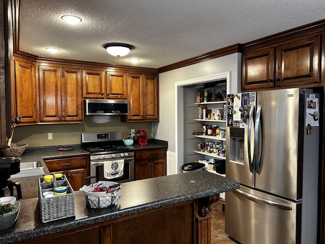 kitchen featuring appliances with stainless steel finishes, dark countertops, crown molding, and a textured ceiling