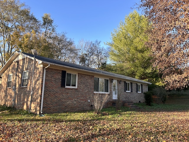 ranch-style house featuring brick siding, crawl space, and a front yard