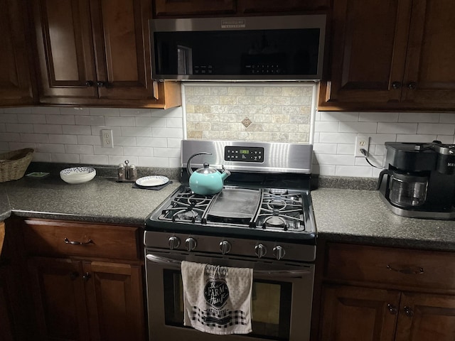 kitchen featuring dark countertops, appliances with stainless steel finishes, and decorative backsplash