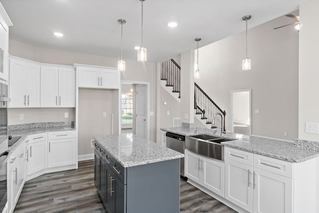 kitchen with white cabinets, dark hardwood / wood-style flooring, pendant lighting, and light stone countertops