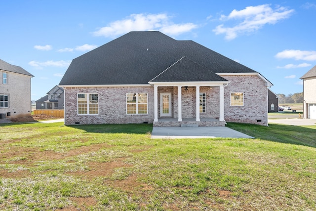 back of property with a patio, a yard, and a garage