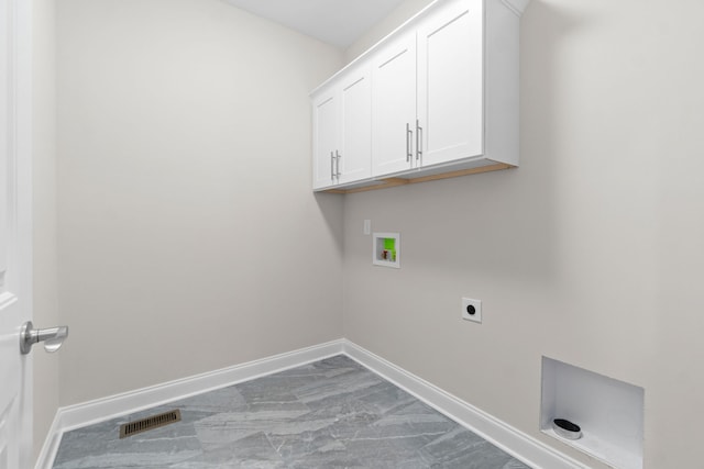 laundry room featuring electric dryer hookup, hookup for a washing machine, tile flooring, and cabinets