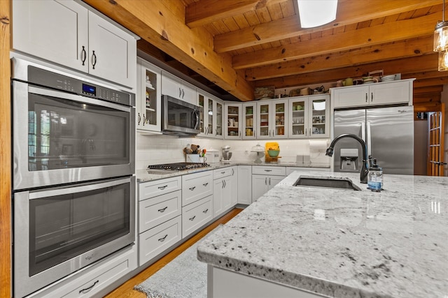 kitchen with white cabinets, tasteful backsplash, beam ceiling, stainless steel appliances, and wooden ceiling