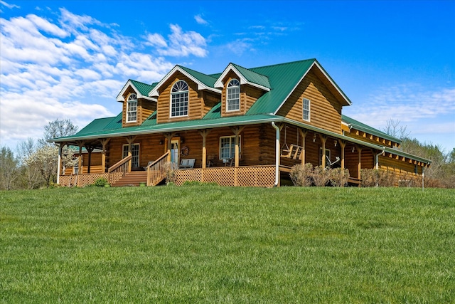 log home with covered porch and a front yard