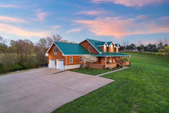 log cabin with a yard, a garage, and covered porch