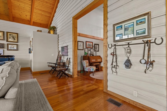 living room with high vaulted ceiling, wood ceiling, hardwood / wood-style floors, and wooden walls