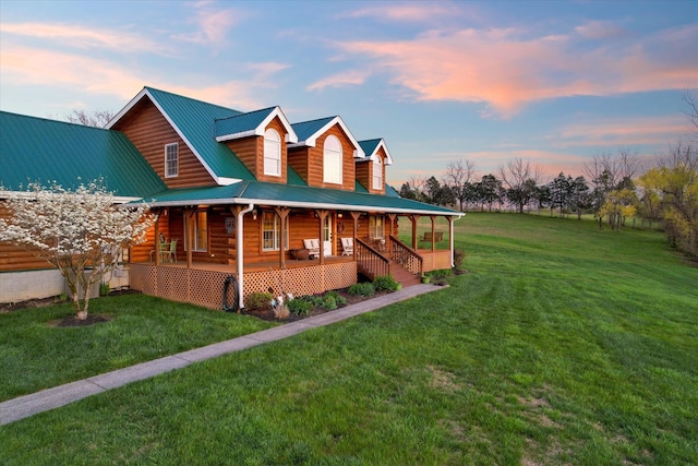 view of front of property featuring covered porch and a yard