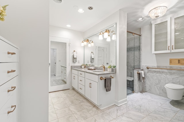 bathroom with tile walls, walk in shower, toilet, vanity, and tile floors