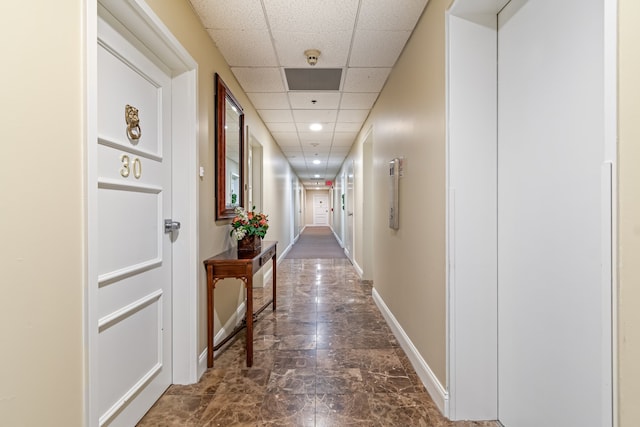 corridor featuring tile flooring and a paneled ceiling