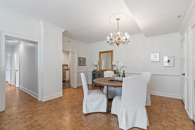 dining area with parquet floors, a notable chandelier, and ornamental molding