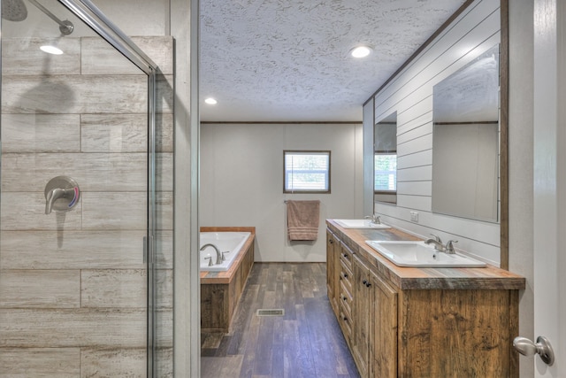 5077 Southpoint Ridge Rd, Hampshire, TN 38461 - bathroom featuring wooden walls, wood-type flooring, double vanity, shower with separate bathtub, and a textured ceiling