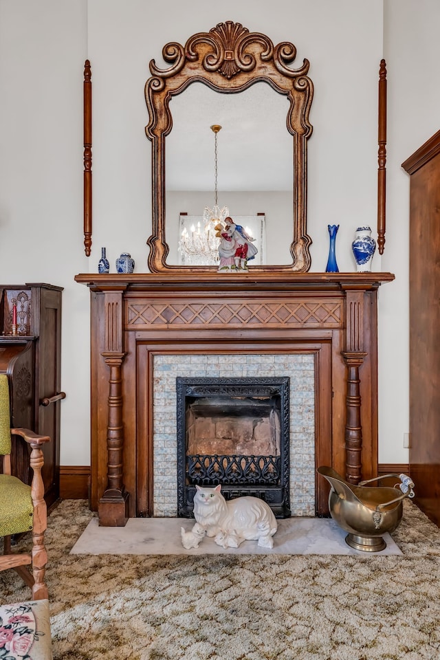 details with a tile fireplace and a chandelier