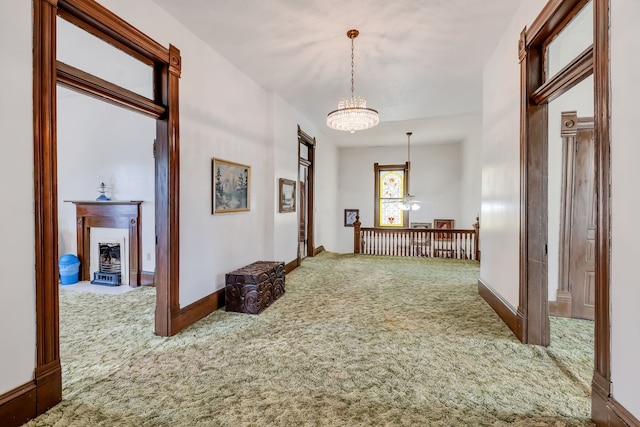 hall featuring carpet floors and a notable chandelier