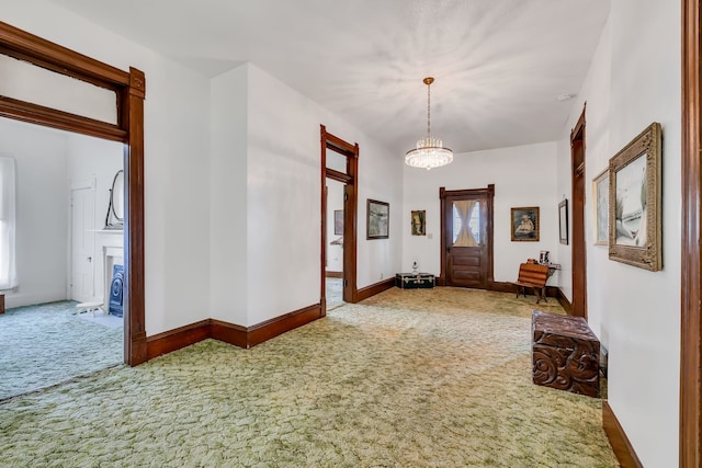 foyer with carpet and a chandelier