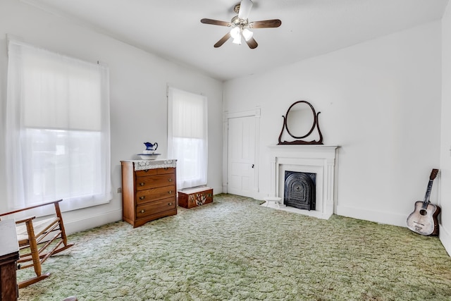 carpeted living room featuring a fireplace, ceiling fan, and a healthy amount of sunlight