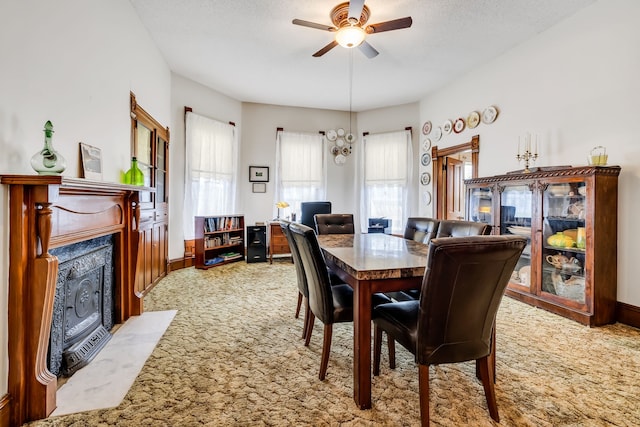 dining area with carpet flooring, ceiling fan with notable chandelier, and a textured ceiling