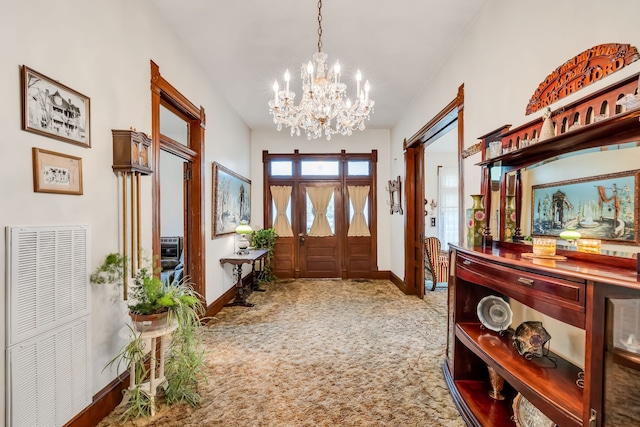 carpeted foyer featuring french doors and a notable chandelier