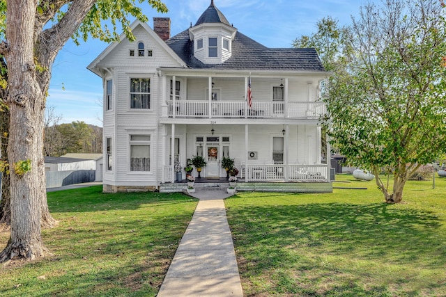 victorian house with covered porch, a balcony, and a front lawn