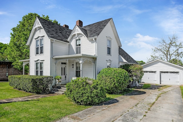 view of front of property featuring an outdoor structure, a front yard, and a garage