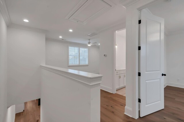 corridor with ornamental molding and hardwood / wood-style floors