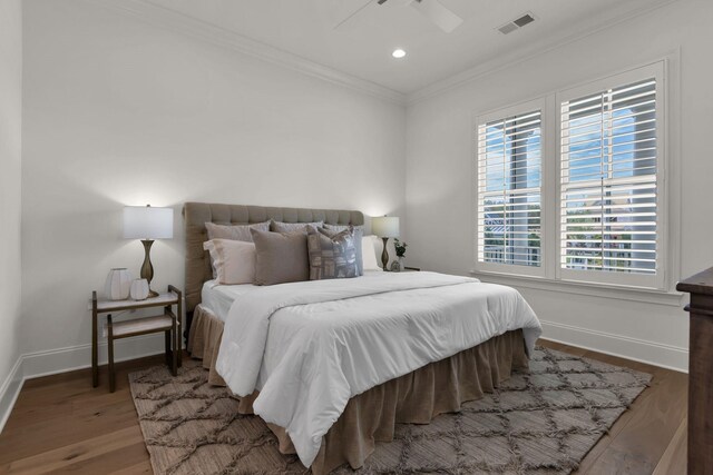 bedroom featuring crown molding, ceiling fan, wood-type flooring, and multiple windows